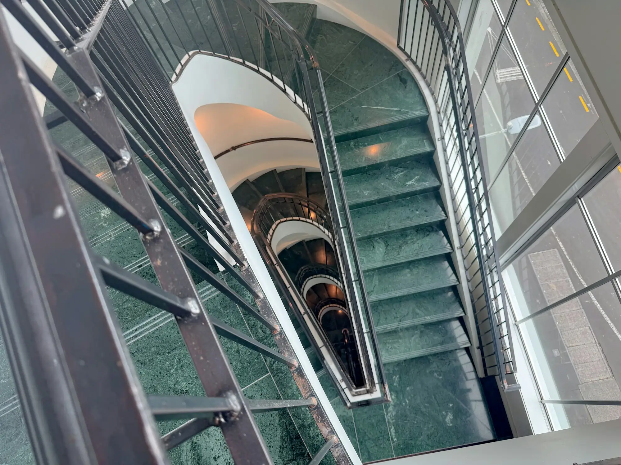 Escalera en espiral con peldaños de mármol verde vista desde arriba