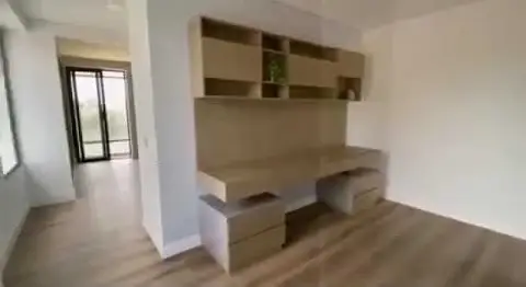 Escritorio y repisas de madera hechos a medida en una habitación terminada